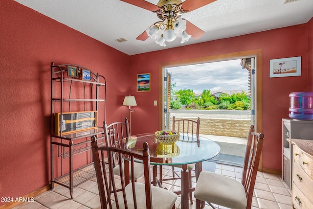 dining area featuring ceiling fan, a textured ceiling, and light tile patterned floors