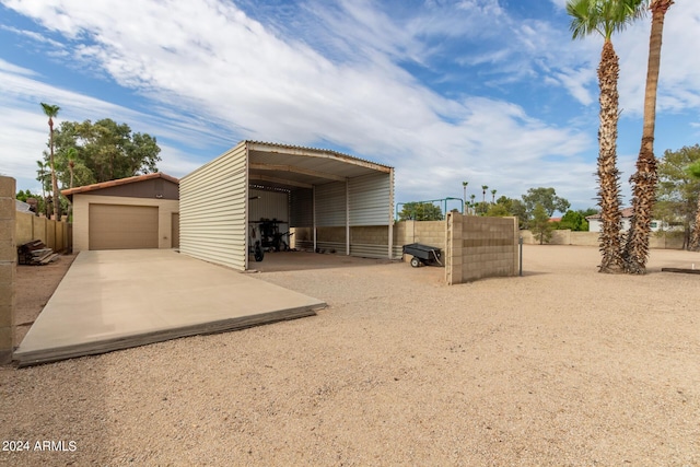 view of outdoor structure with a carport and a garage