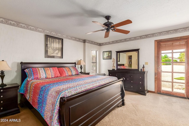 carpeted bedroom featuring ceiling fan and a textured ceiling