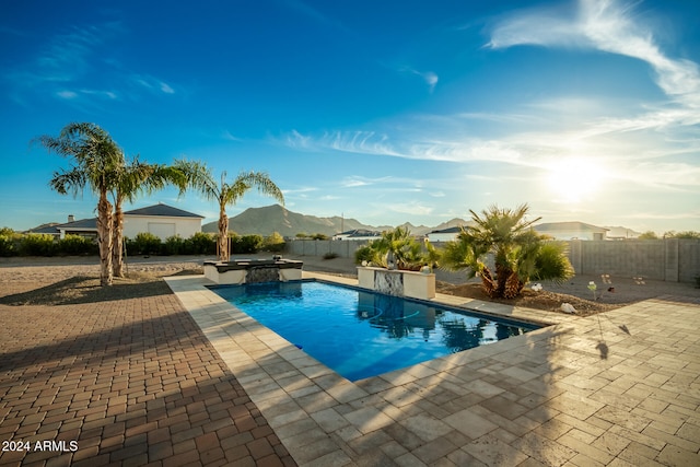 view of swimming pool featuring an in ground hot tub, a patio area, and a mountain view