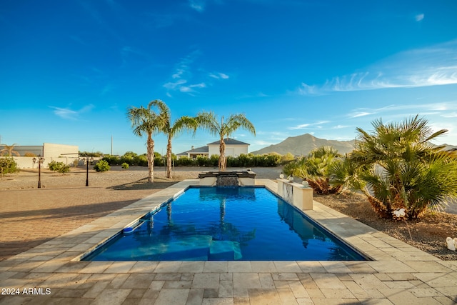 view of swimming pool with a patio area and a mountain view