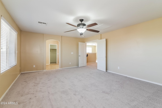 unfurnished bedroom featuring a spacious closet, ceiling fan, and light colored carpet