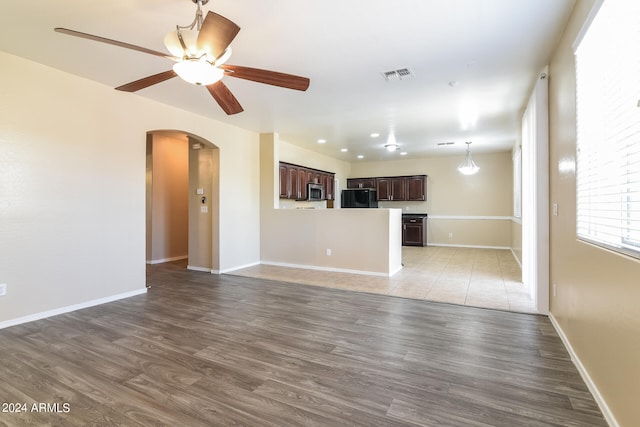 unfurnished living room featuring ceiling fan and hardwood / wood-style floors