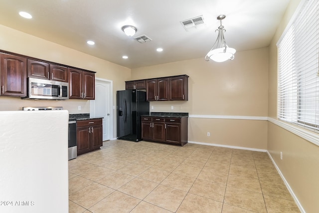 kitchen with dark brown cabinets, light tile patterned floors, black fridge, range, and pendant lighting