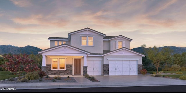 view of front facade featuring driveway, stucco siding, a garage, stone siding, and a mountain view