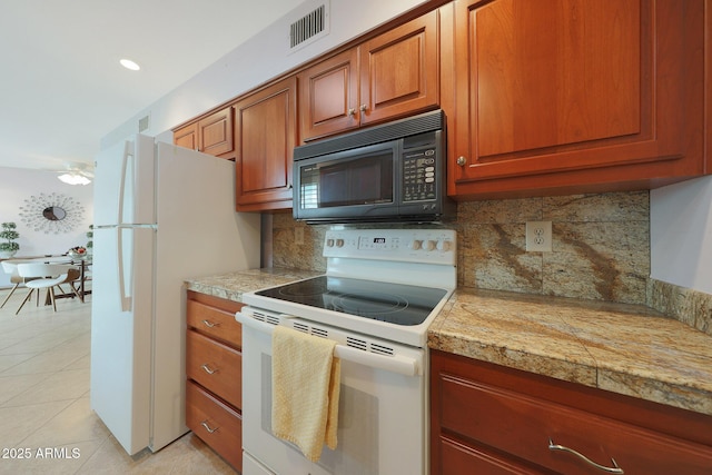 kitchen featuring brown cabinets, tile countertops, visible vents, light tile patterned flooring, and white appliances