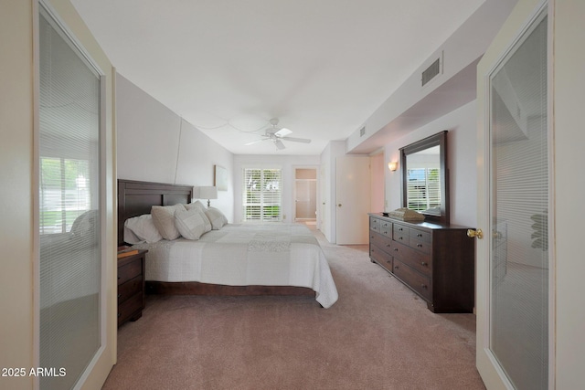 bedroom with a ceiling fan, light carpet, and visible vents