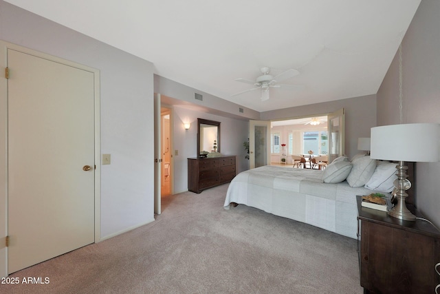 bedroom with light carpet, visible vents, and a ceiling fan