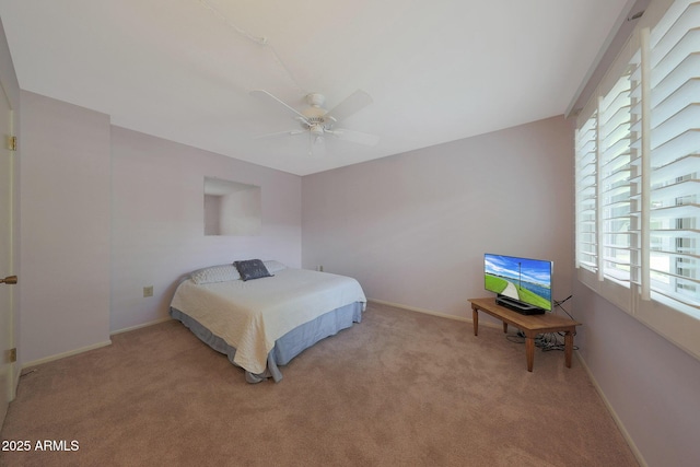 bedroom featuring a ceiling fan, light colored carpet, and baseboards