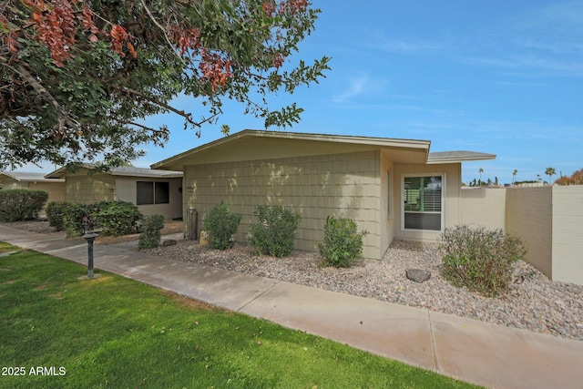 single story home featuring a front yard and fence