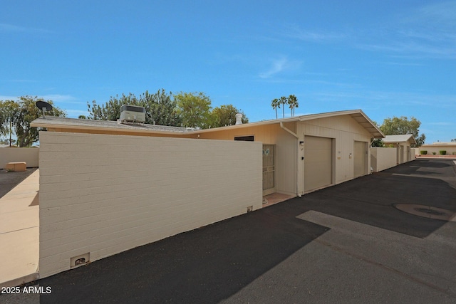 exterior space featuring a garage and fence