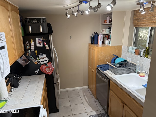4615 N 22nd St Unit 113, Phoenix, AZ 85016 - kitchen featuring light tile patterned floors, dishwasher, a sink, stove, and decorative backsplash