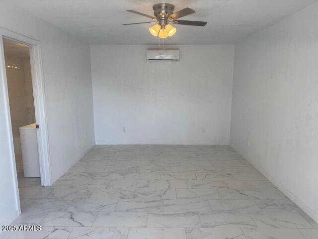 empty room featuring a wall unit AC and ceiling fan