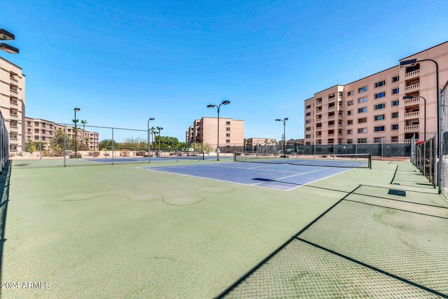 view of tennis court featuring basketball hoop