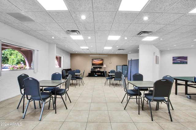 tiled dining space featuring a drop ceiling