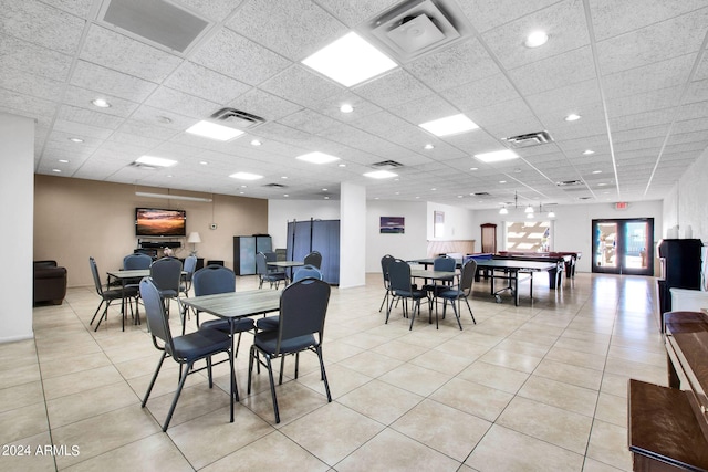 tiled dining area with a drop ceiling