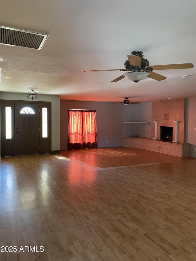 unfurnished living room with hardwood / wood-style floors and ceiling fan