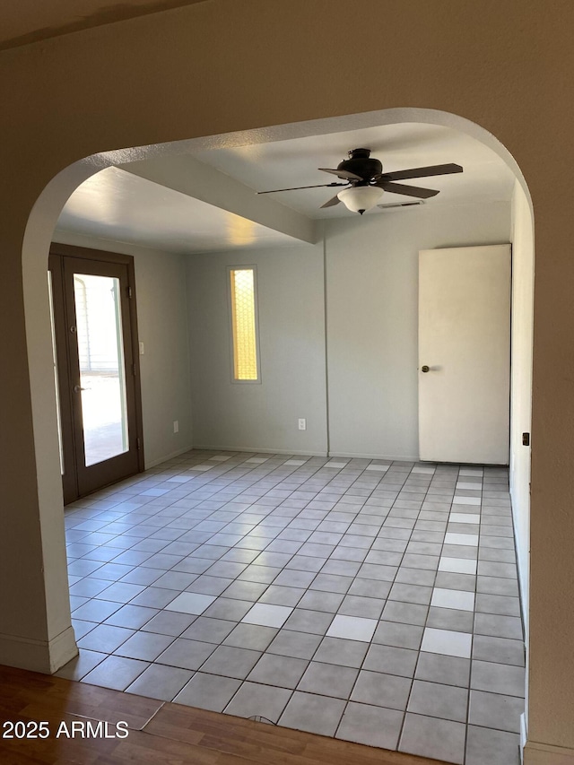 tiled spare room featuring ceiling fan