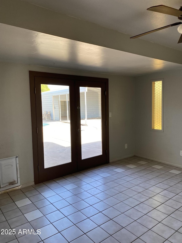 tiled empty room featuring french doors and ceiling fan