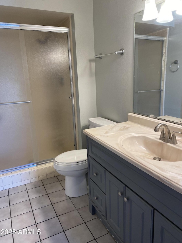 bathroom featuring walk in shower, tile patterned floors, toilet, and vanity