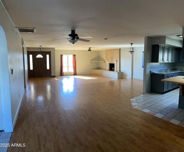 unfurnished living room with ceiling fan and light wood-type flooring