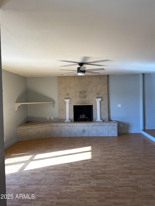 unfurnished living room featuring ceiling fan, a fireplace, and hardwood / wood-style floors