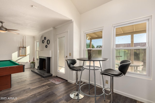 interior space with pool table, ceiling fan, a brick fireplace, vaulted ceiling, and dark hardwood / wood-style flooring