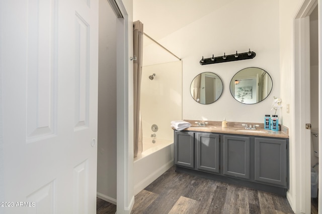 bathroom featuring shower / tub combination, double sink vanity, and wood-type flooring