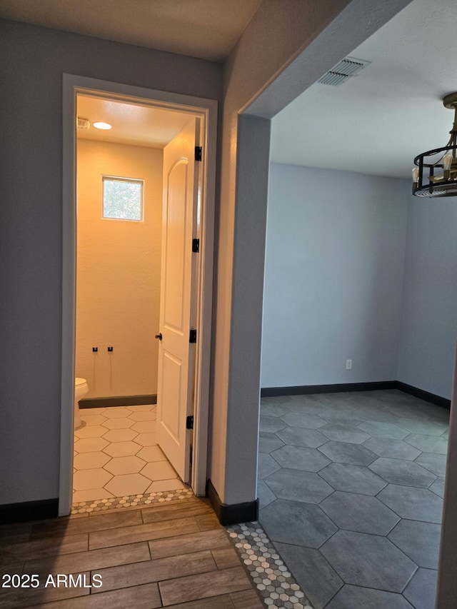 9302 W Georgia Ave, Glendale, AZ 85305 - hallway with a chandelier and baseboards
