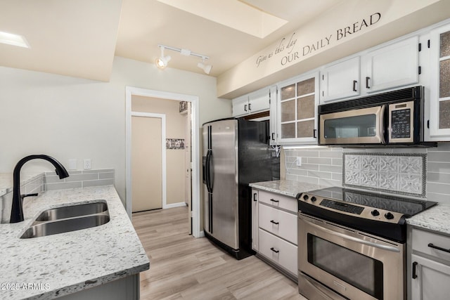 kitchen featuring white cabinetry, stainless steel appliances, sink, and decorative backsplash