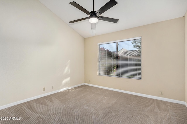 carpeted spare room with ceiling fan and vaulted ceiling