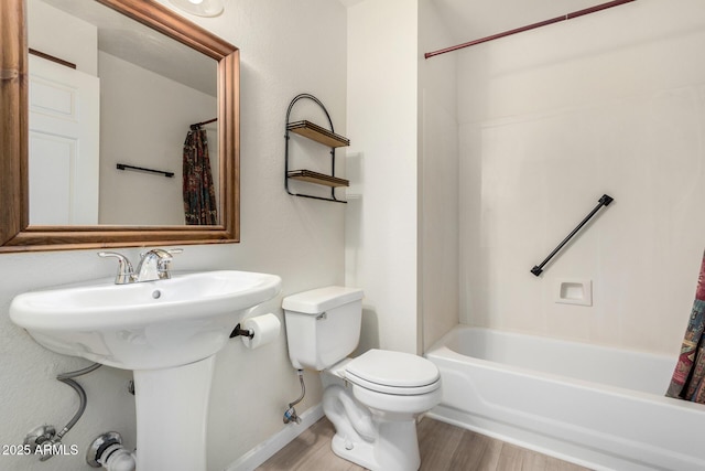 bathroom with shower / tub combo, hardwood / wood-style flooring, and toilet