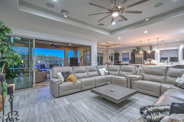 living room featuring a tray ceiling and ceiling fan