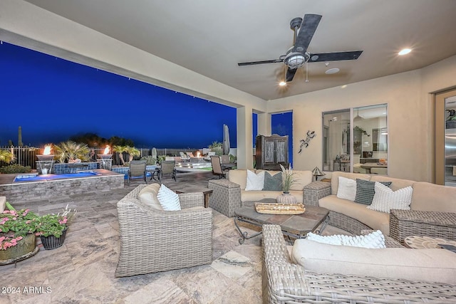 patio at twilight with ceiling fan and an outdoor hangout area