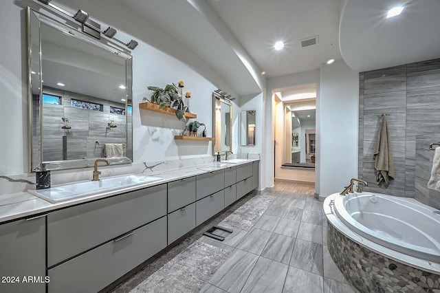 bathroom featuring vanity and independent shower and bath