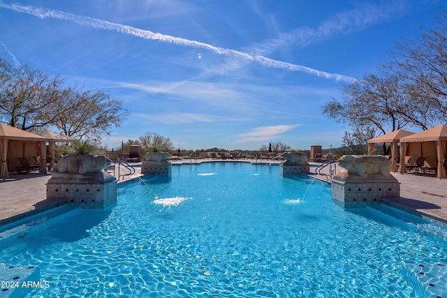 view of swimming pool featuring pool water feature and a patio