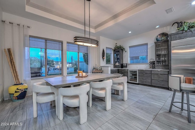 dining room with a raised ceiling and beverage cooler