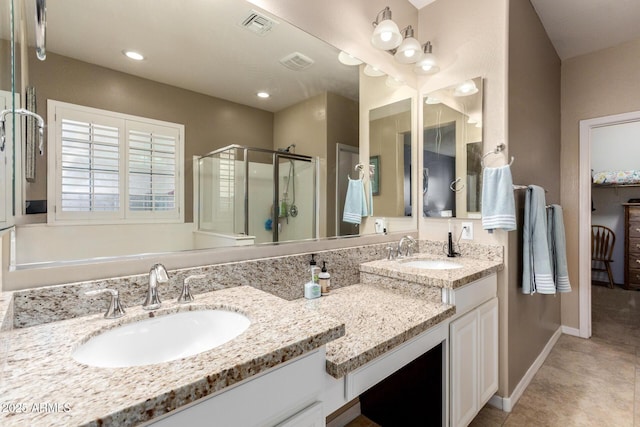 bathroom with visible vents, a stall shower, and a sink