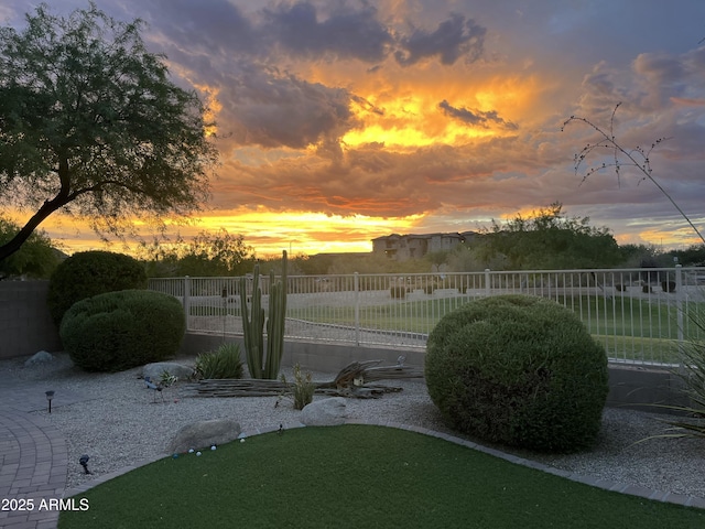 yard at dusk featuring fence