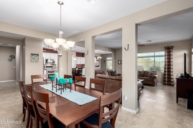 dining space featuring light tile patterned floors, baseboards, and a chandelier