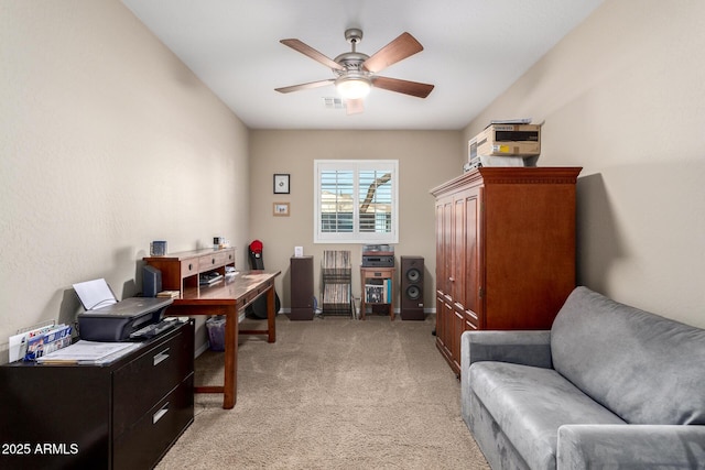 home office featuring baseboards, a ceiling fan, visible vents, and light carpet