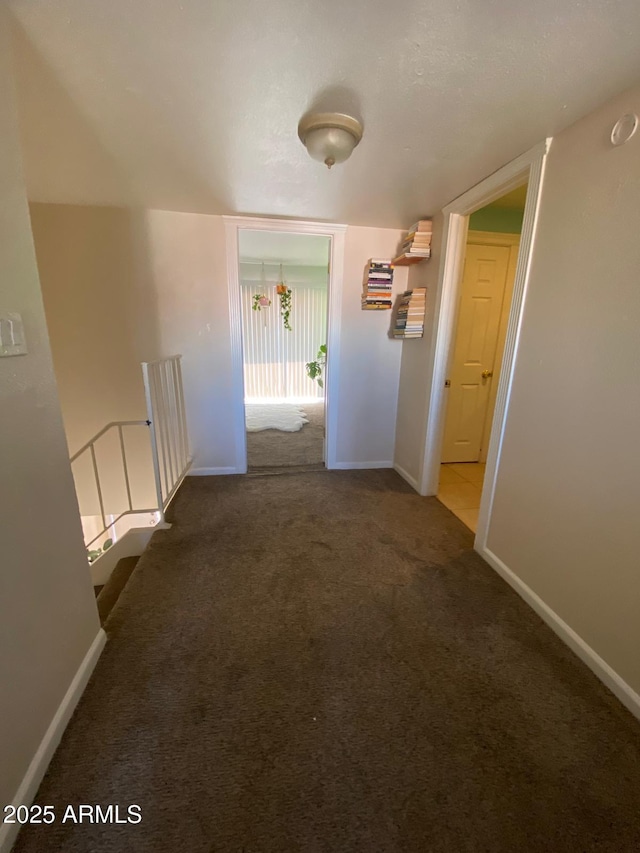 hall featuring carpet and baseboards