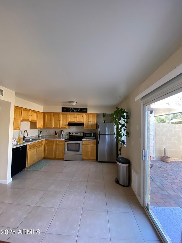 kitchen featuring light tile patterned flooring, a sink, light countertops, appliances with stainless steel finishes, and range hood