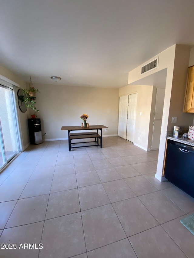 interior space featuring light tile patterned flooring, visible vents, and baseboards