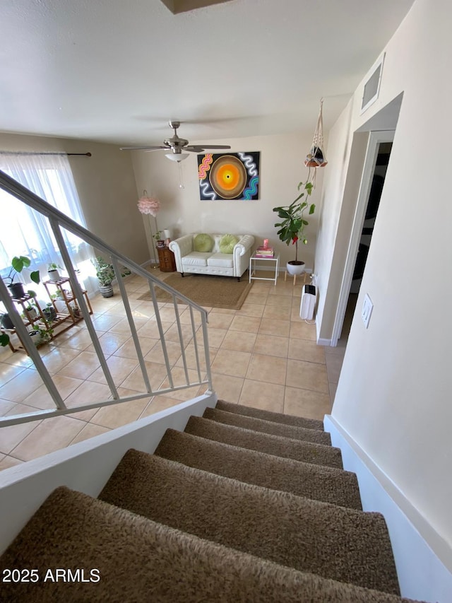 stairway featuring visible vents, a ceiling fan, and tile patterned floors