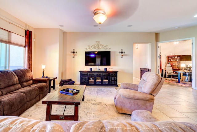 living room with tile patterned floors and a ceiling fan