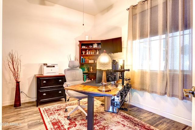 home office with baseboards and wood finished floors