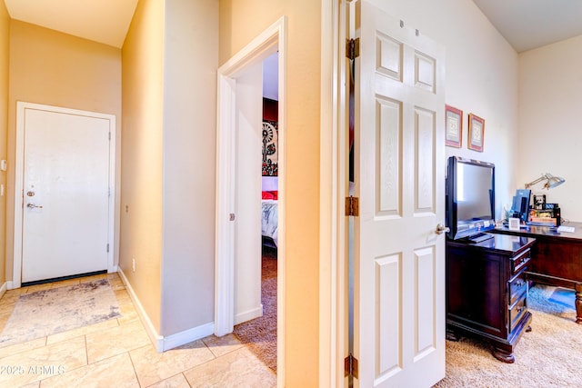 corridor with light tile patterned floors and baseboards