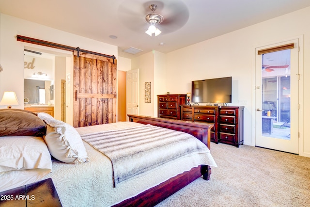 carpeted bedroom featuring visible vents, access to exterior, ensuite bath, a barn door, and ceiling fan