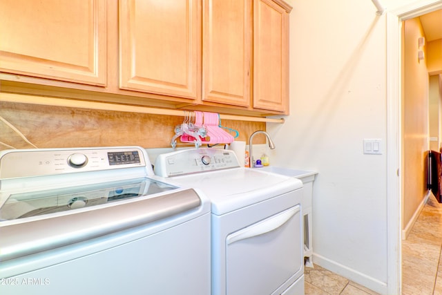 clothes washing area with cabinet space, washing machine and dryer, and baseboards